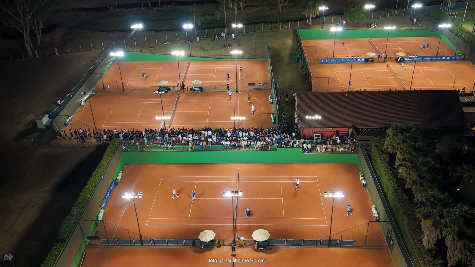 Vista aérea noturna das quadras lotadas durante a BTG Pactual Tennis Week 2025